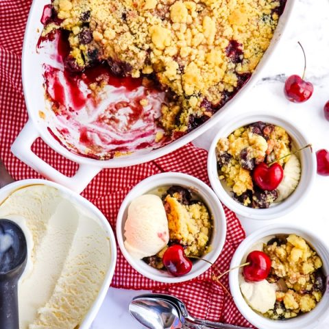 Cherry cobbler with cake mix served out of baking dish and into small bowls with ice cream.