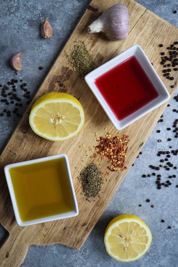 ingredients for healthy Italian dressing on wooden board.