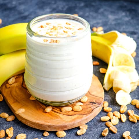 Peanut butter banana smoothie, garnished with peanut and bananas.