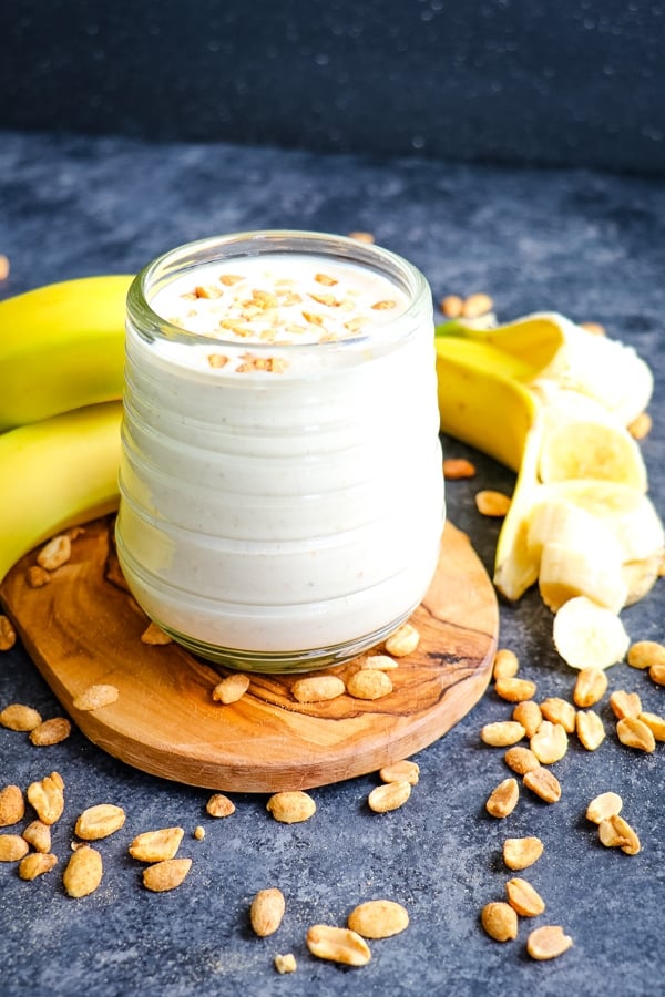 Peanut butter banana smoothie, garnished with peanut and bananas.