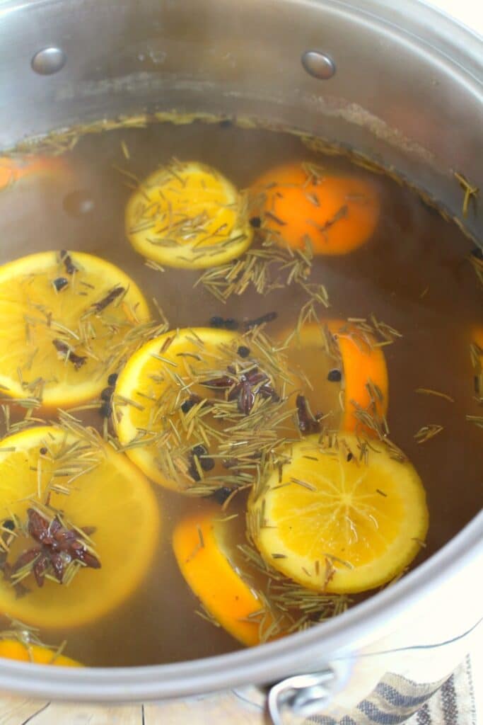 Simmered apple cider turkey brine with orange slices.