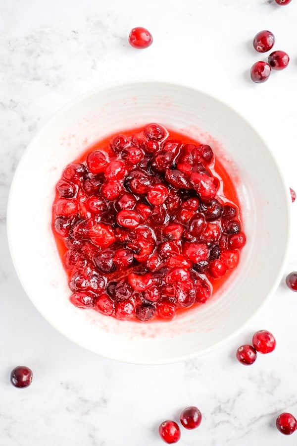Cooked cranberries in white bowl.
