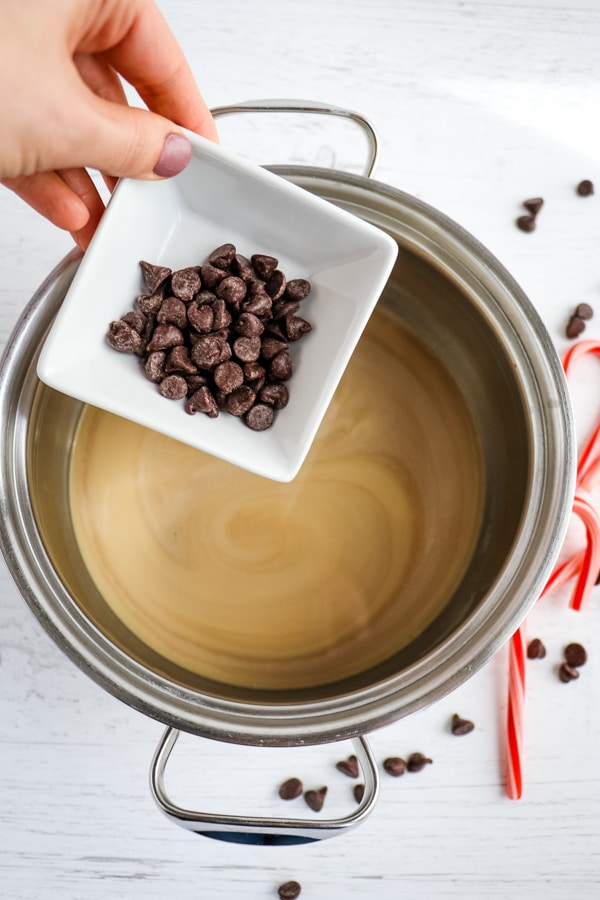 Adding chocolate chips to sauce pan with milk and coffee.