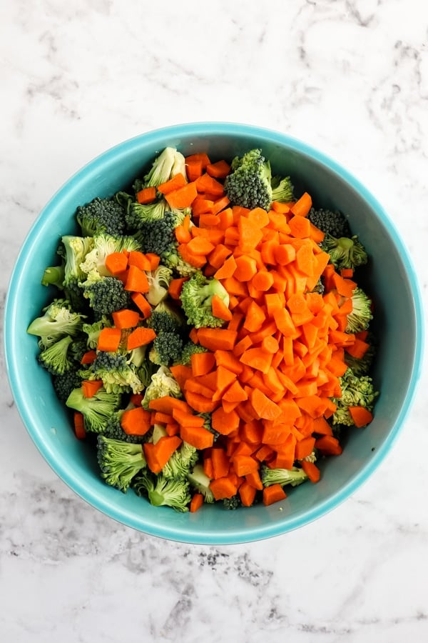 Broccoli and diced carrots in blue bowl.