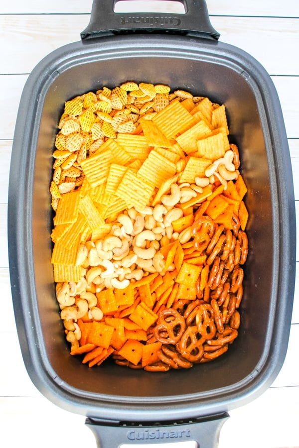Snack mix ingredients in slow cooker.