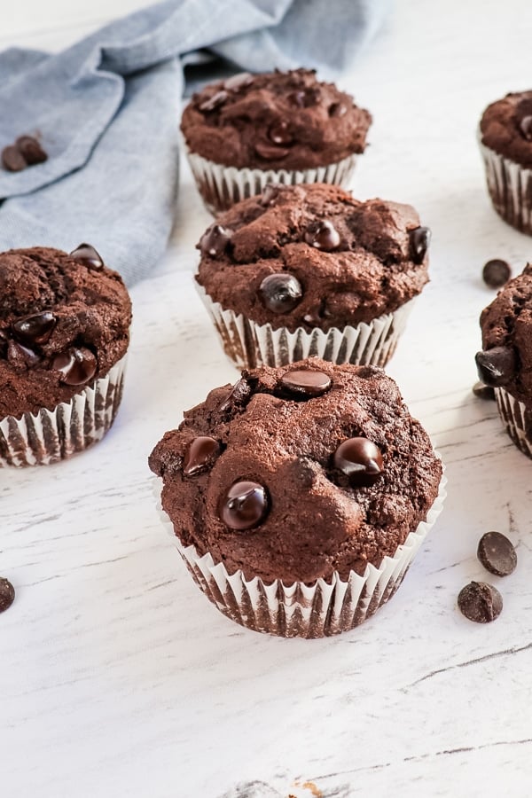 Healthy chocolate muffins garnished with chocolate chips and blue napkin.