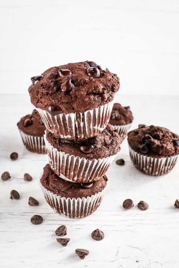 Stack of 3 double chocolate muffins, garnished with chocolate chips.