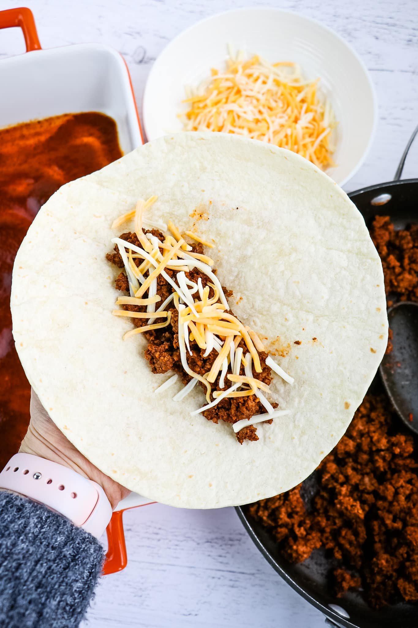 How to roll an enchilada, with ground beef and cheese.