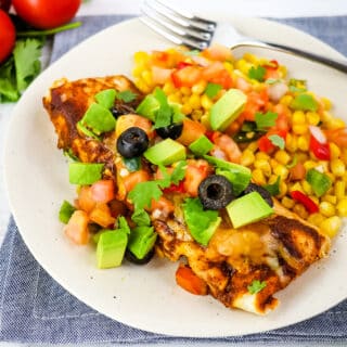 Ground beef enchilada with red sauce, topped with salsa, avocados and olives.