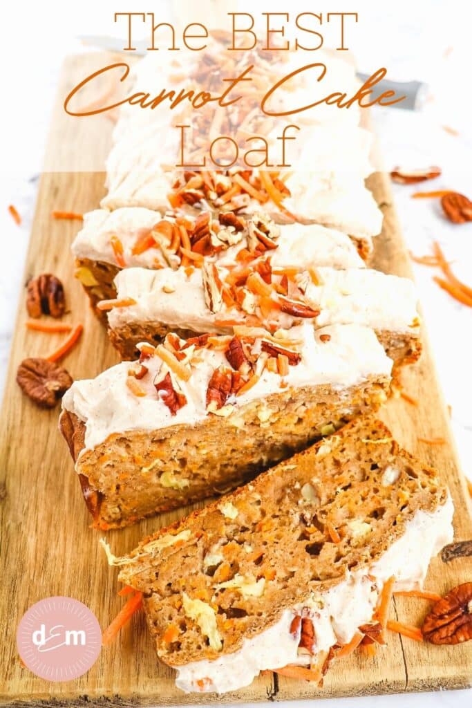Sliced carrot cake loaf, topped with cream cheese frosting, pecans and carrot shreds.