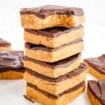 Stack of peanut butter protein bars with top bar bite take out.