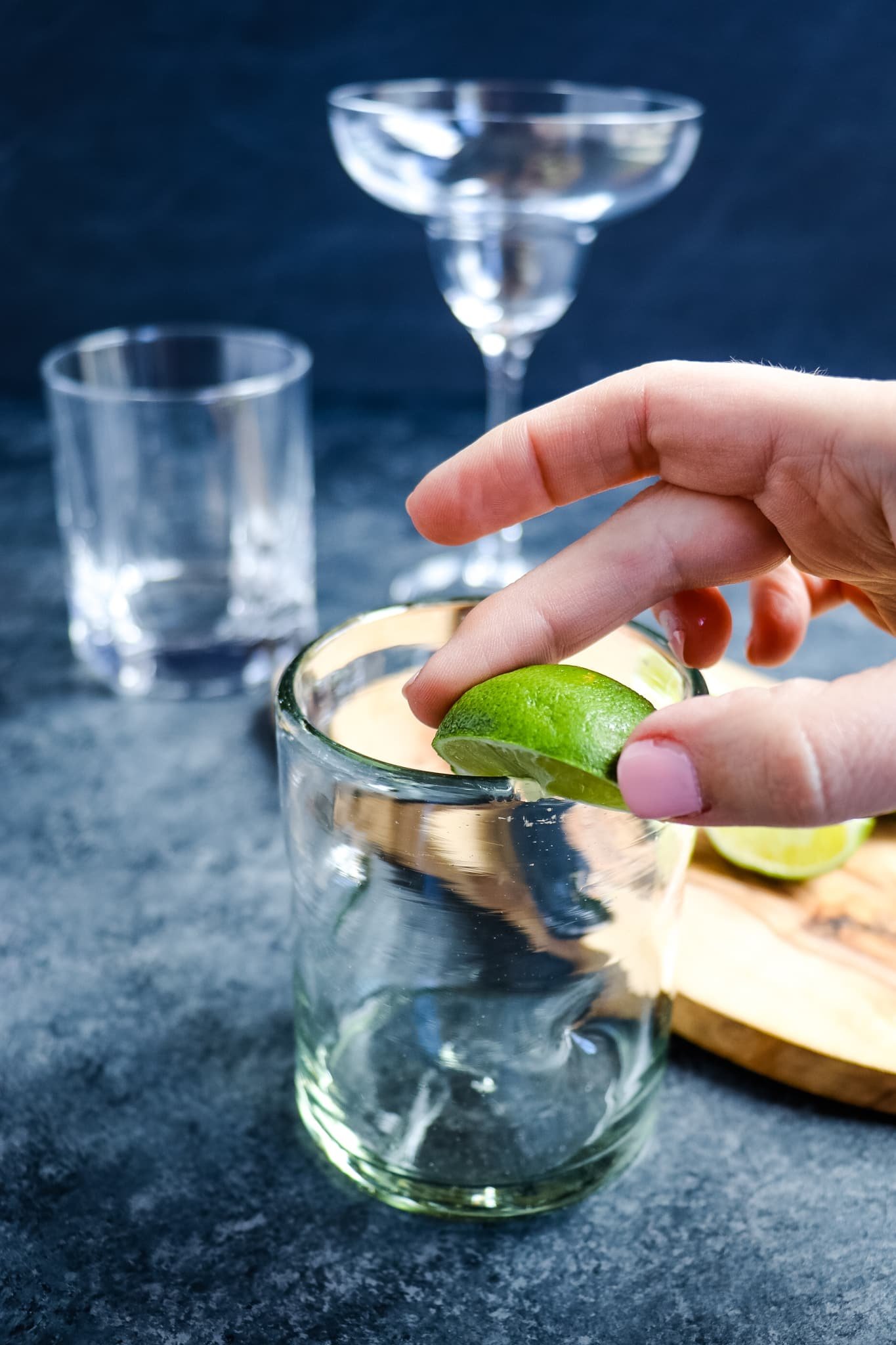 Running a lime around the edge of a glass to salt the rim.
