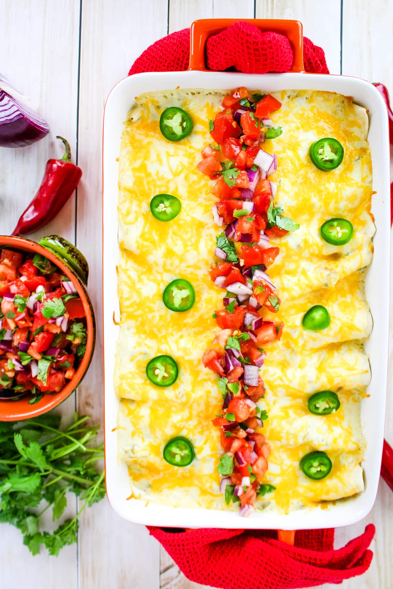 Sour cream enchiladas topped with melted cheese and pico de gallo salsa.