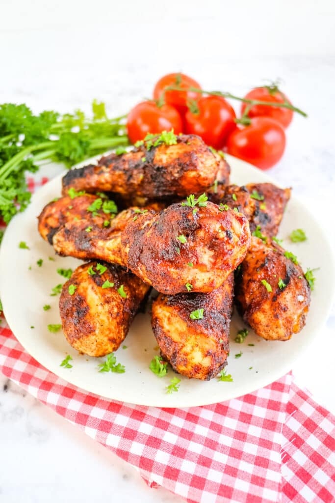 BBQ chicken legs on plate, garnished with parsley.