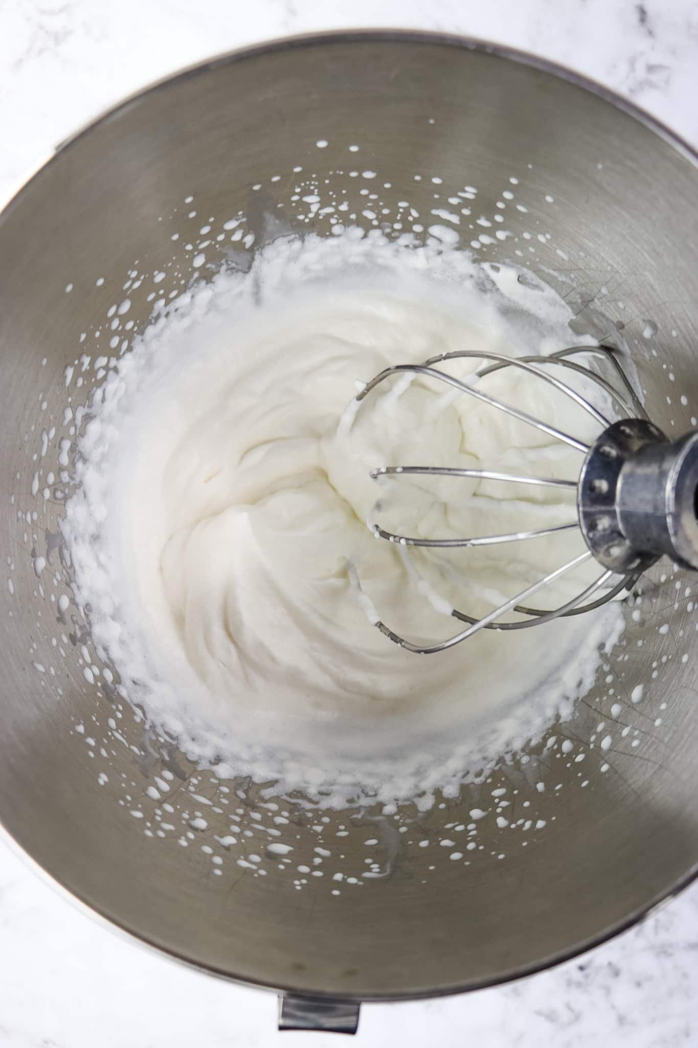 Making whipped cream in mixer with stiff peaks.