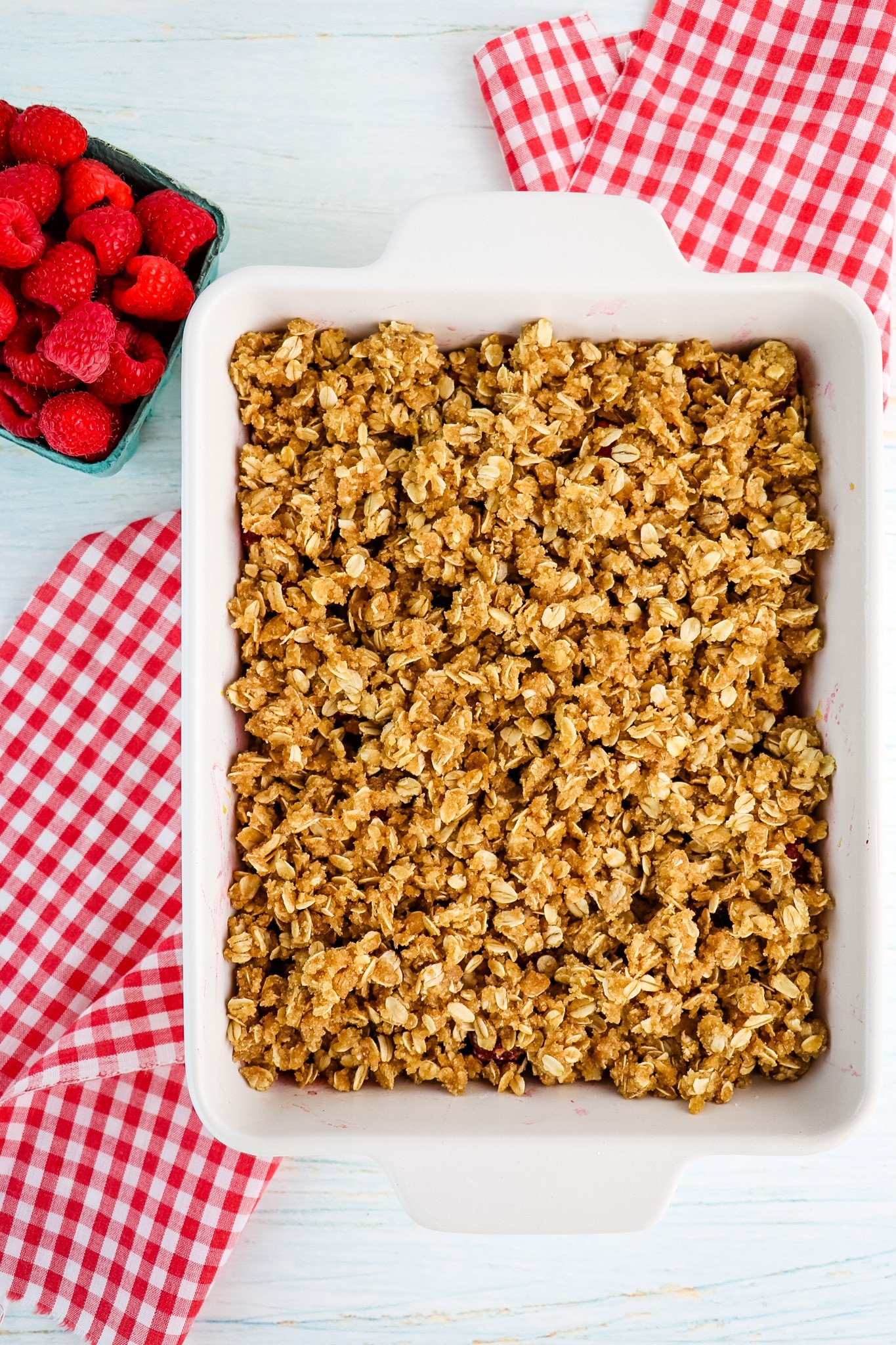 Raspberry crumble with crumble topping and raspberries on the side.