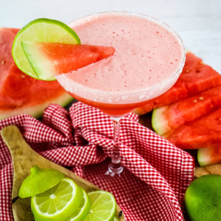 Frozen watermelon margarita garnished with watermelon wedge and lime slice.