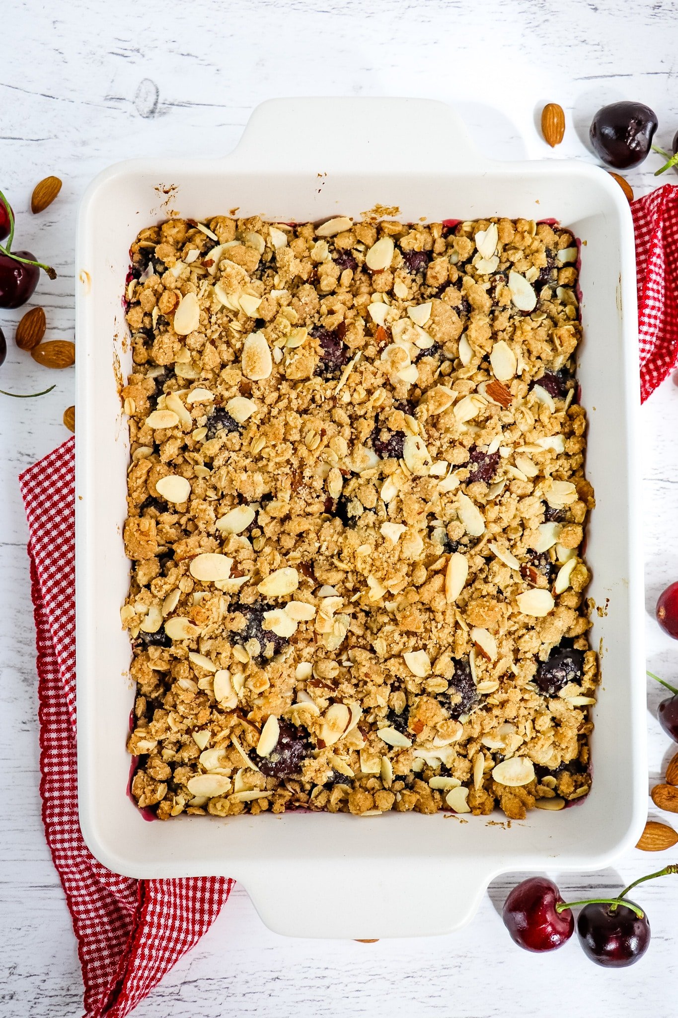 Baked cherry crisp in white baking dish.