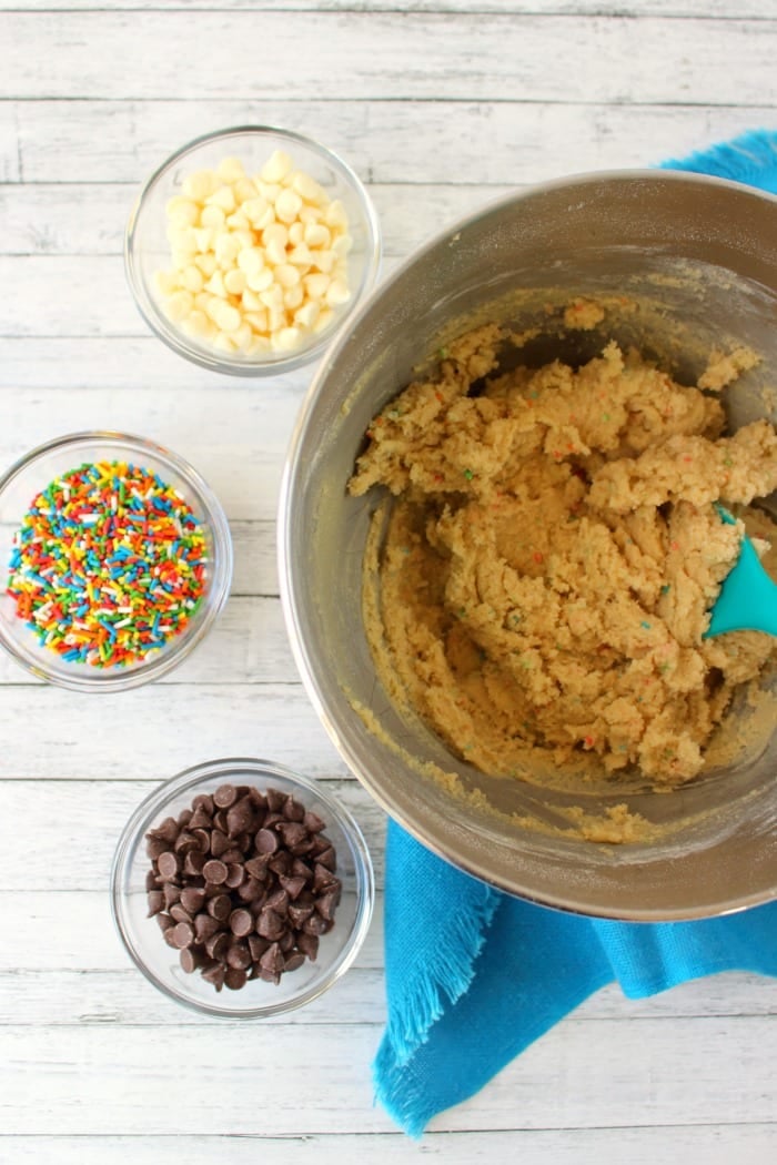 Cookie batter with mix in ingredients on the side in small bowls.