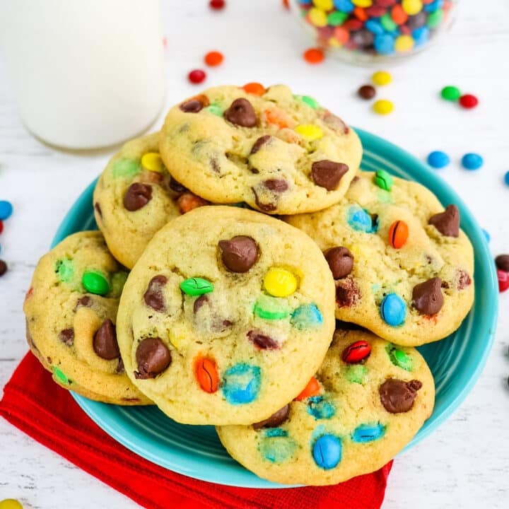 Plate of cookies with garnish of M&M candies and milk in the background.