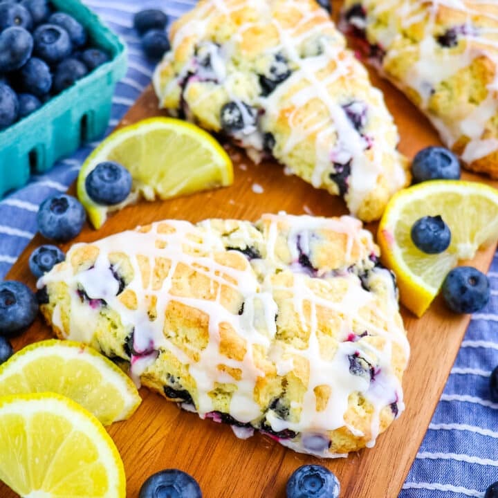 Cream cheese lemon blueberry scones garnished with blueberries and lemon slices.