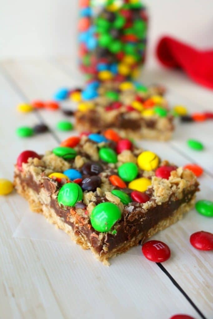 MM oatmeal cookie bars cut into squares on table, with M&M's on the side.
