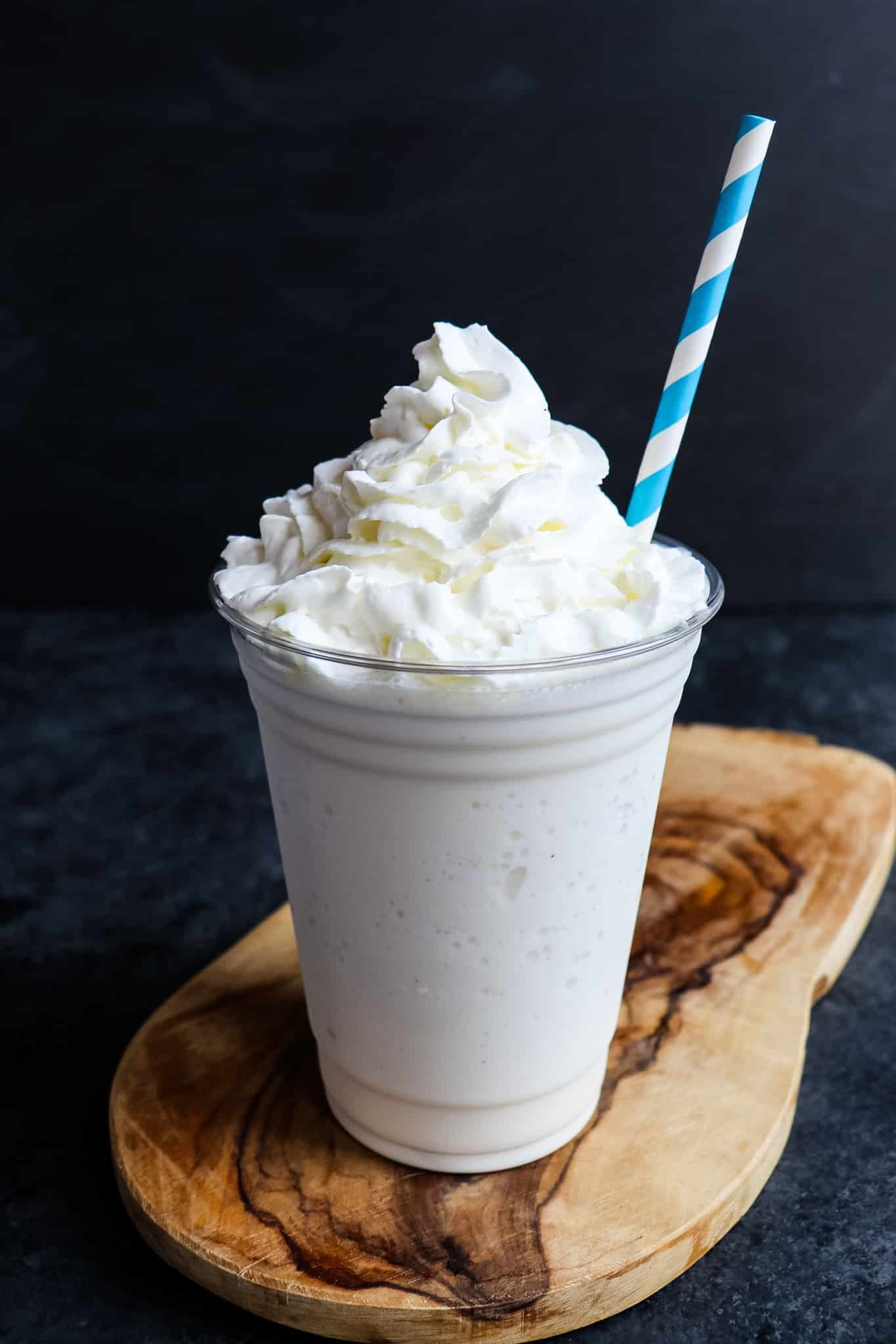 Starbucks vanilla bean frappuccino topped with whipped cream and straw.