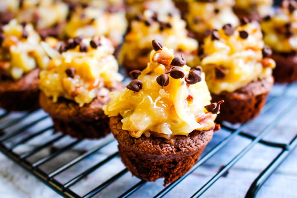 German chocolate brownie bites on a cooling rack topped with mini chocolate chips.