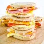 Three healthy breakfast sandwiches stacked together on a board.