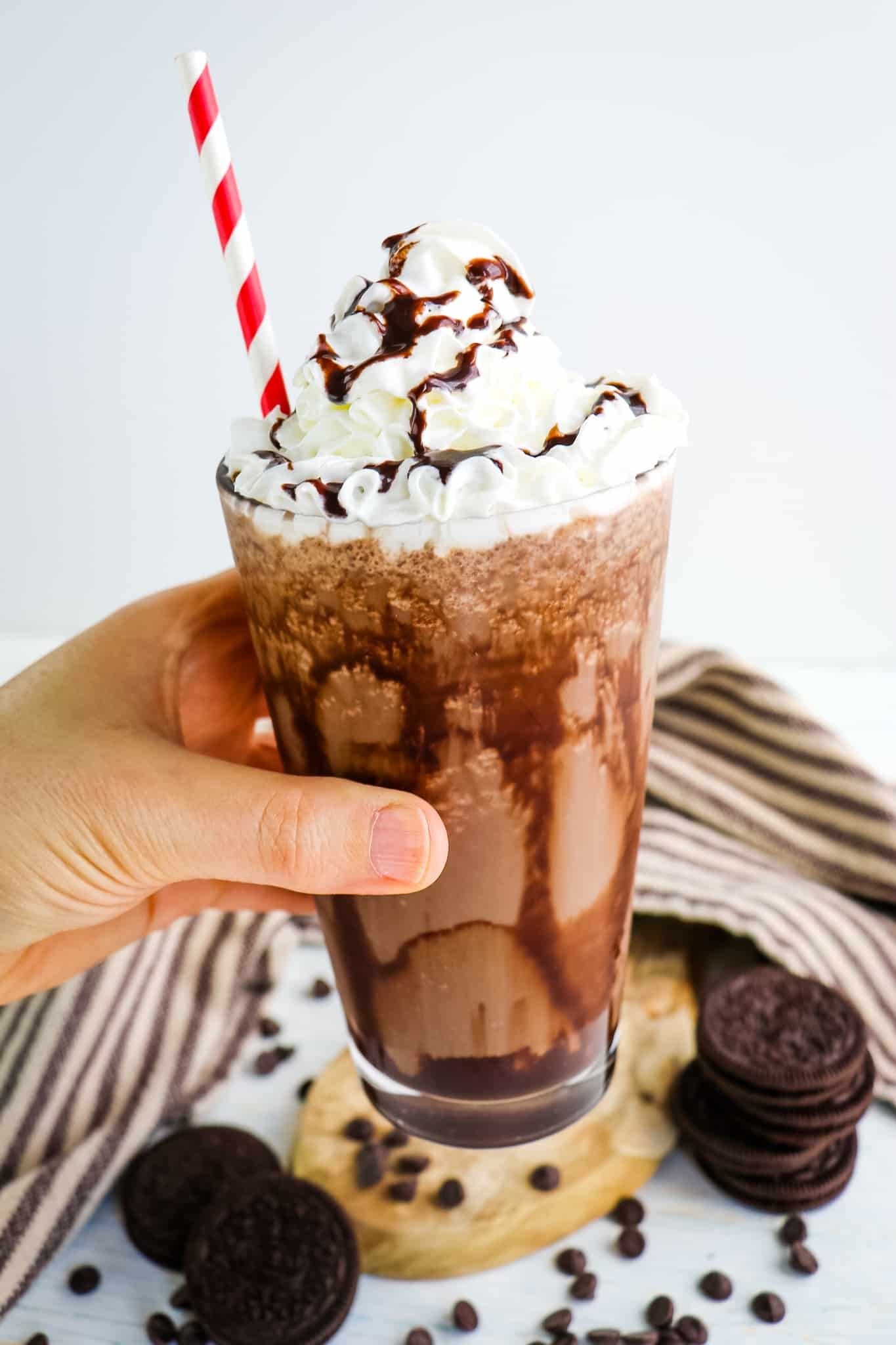 Mocha cookie crumble topped with whipped cream, chocolate sauce and a straw.