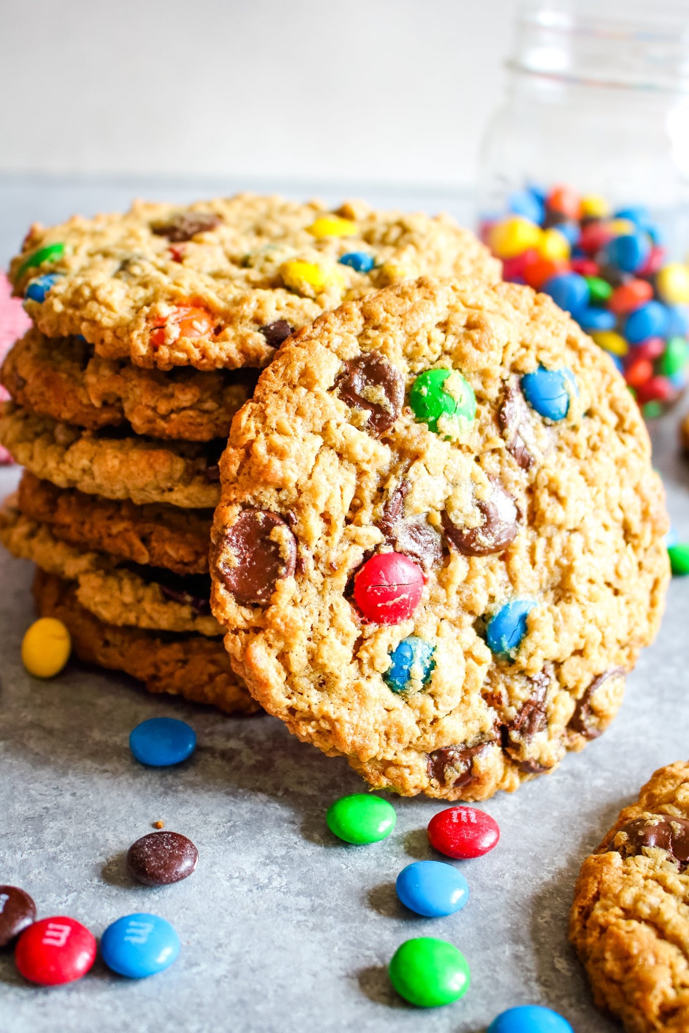 Stack of monster cookies with one cookie on its side.