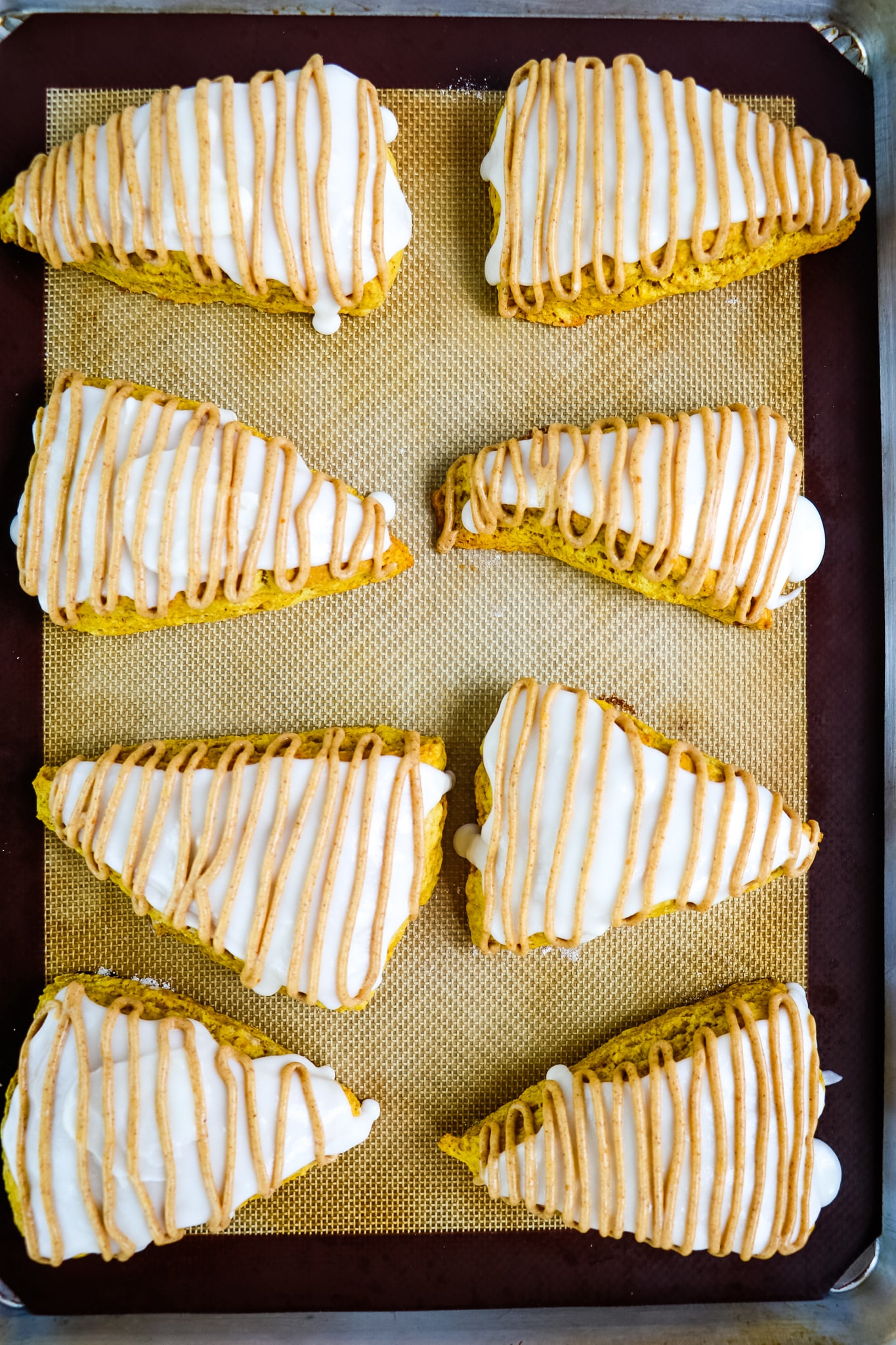 Frosted Starbucks pumpkin scones on baking sheet.