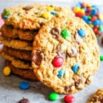 Stack of monster cookies with one cookie on its side.