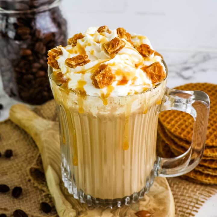 Close up image of caramel brulee latte in glass mug.