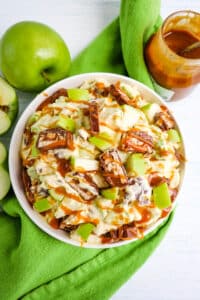 Snickers apple salad with green apples and caramel topping on the side.