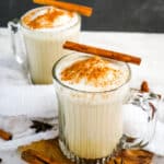 Two mugs of chia tea latte, topped with cinnamon and cinnamon sticks.
