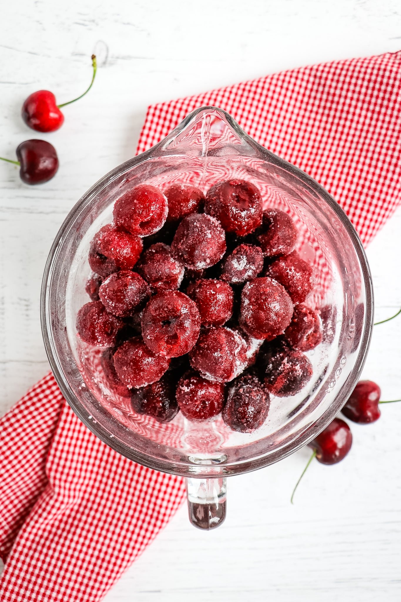 Cherries in bowl, coated with sugar.