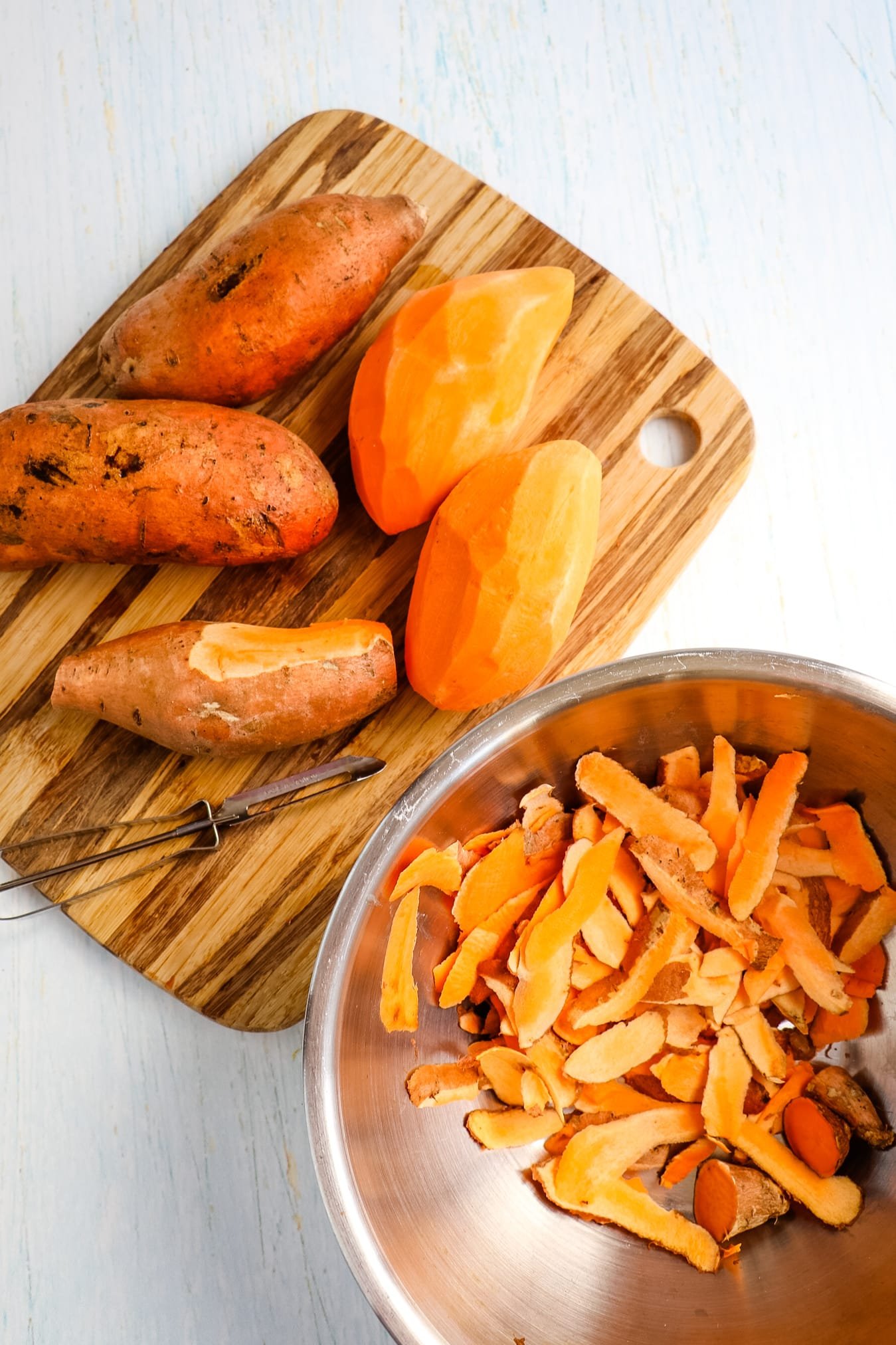 Sweet potatoes being peeled for Hasselback sweet potato recipe.