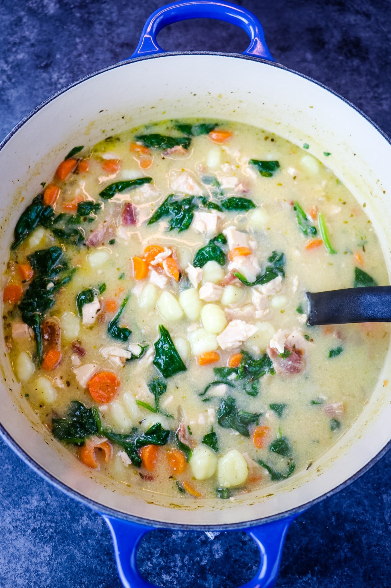 Pot of Olive garden chicken gnocchi soup, with ladle.