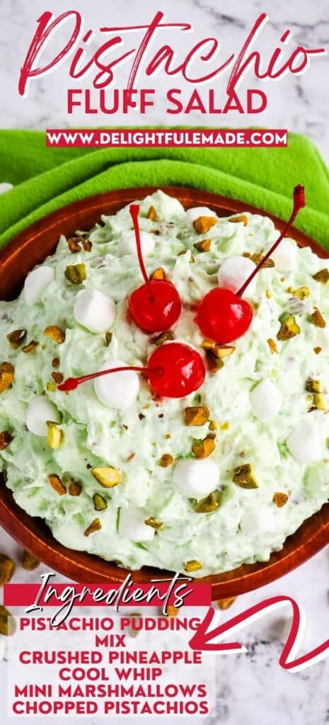 Pistachio fluff salad in bowl, topped with chopped pistachios and maraschino cherries.