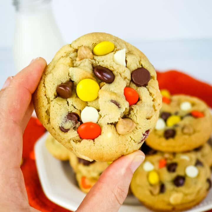 Reese's pieces cookie held in hand.