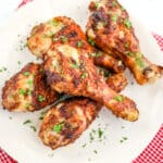 Air fryer drumsticks recipe on plate garnished with fresh chopped parsley.