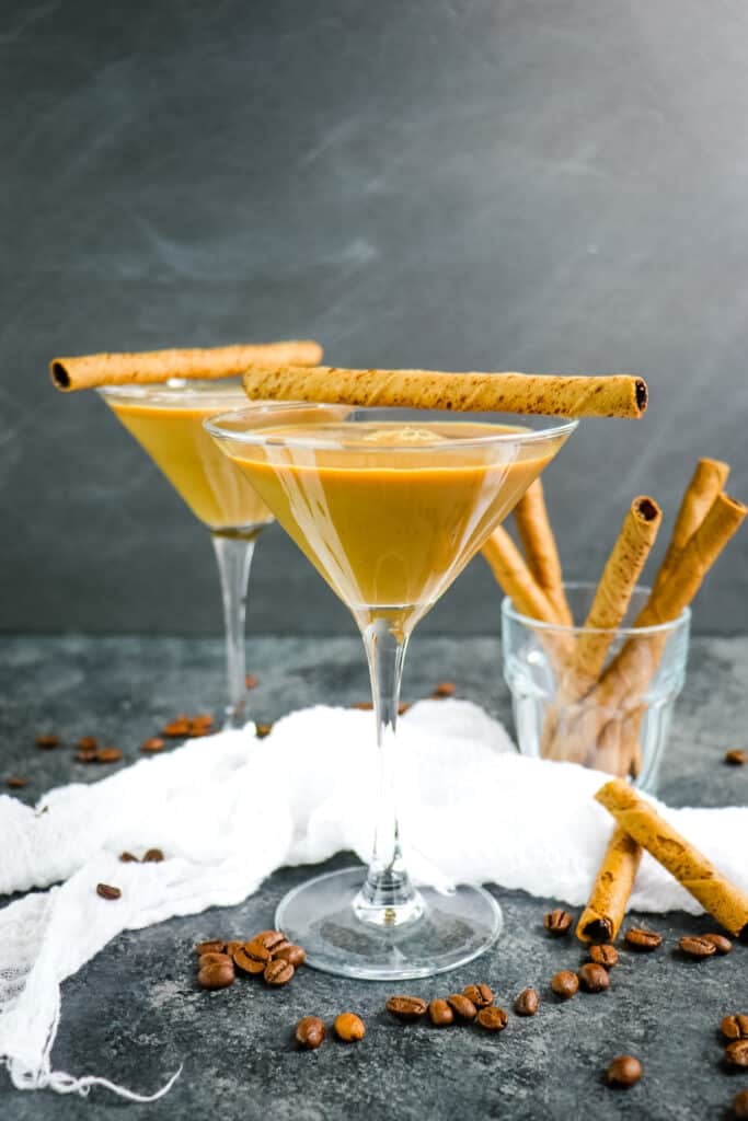 Two Bailey's espresso martini's topped with rolled cookies.