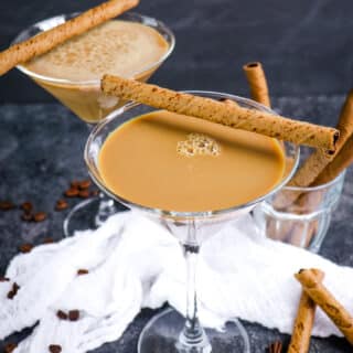 Two Bailey's espresso martini's topped with rolled cookies.