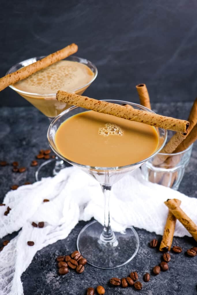 Two Bailey's espresso martini's topped with rolled cookies.