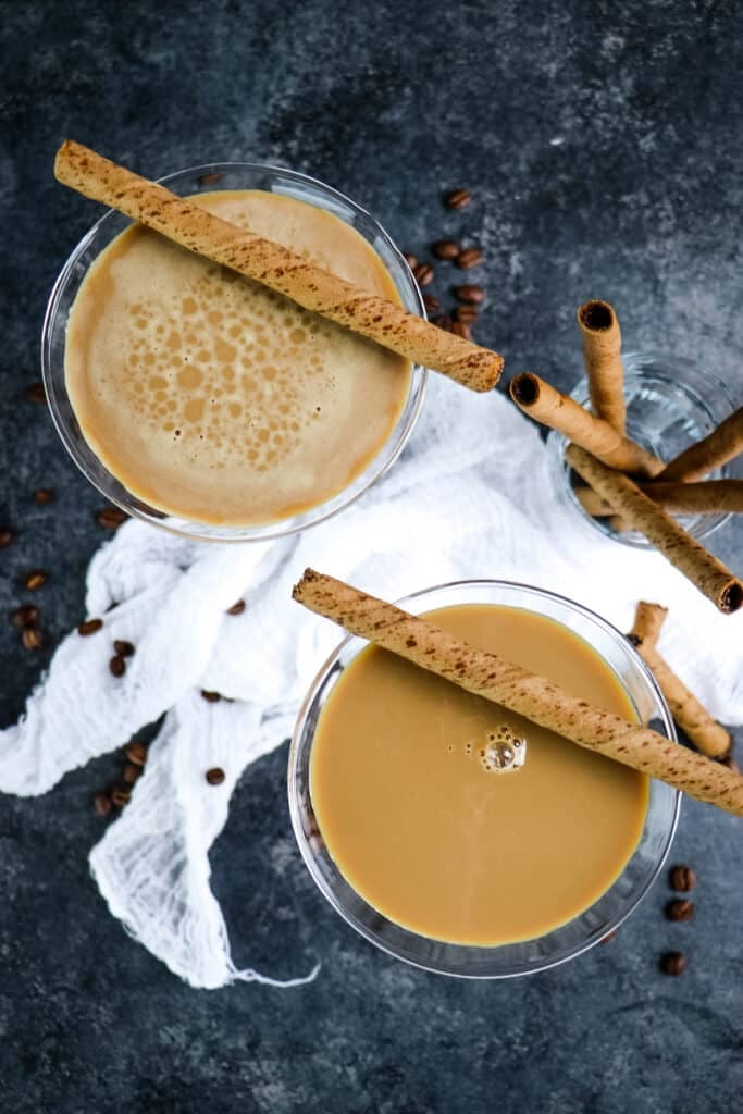 Two creamy espresso martini's topped with rolled cookies.