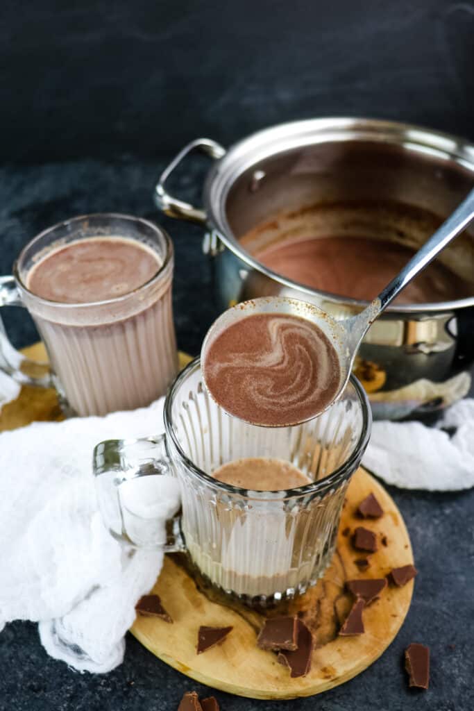 Baileys and hot chocolate being ladled into a mug.