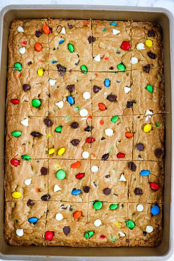 M&M cookie bars in pan and cut into squares.