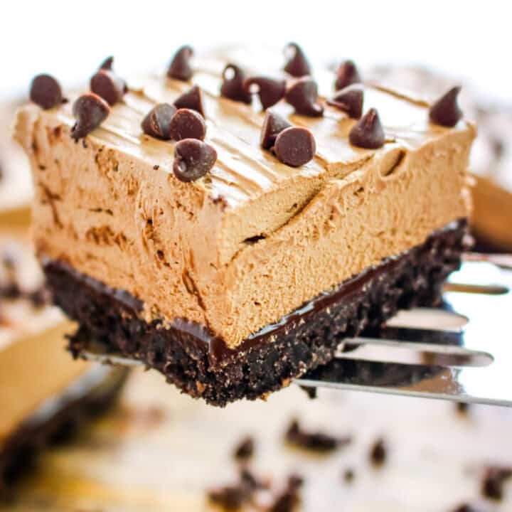 Slice of no bake chocolate cheesecake lifted up on a spatula.