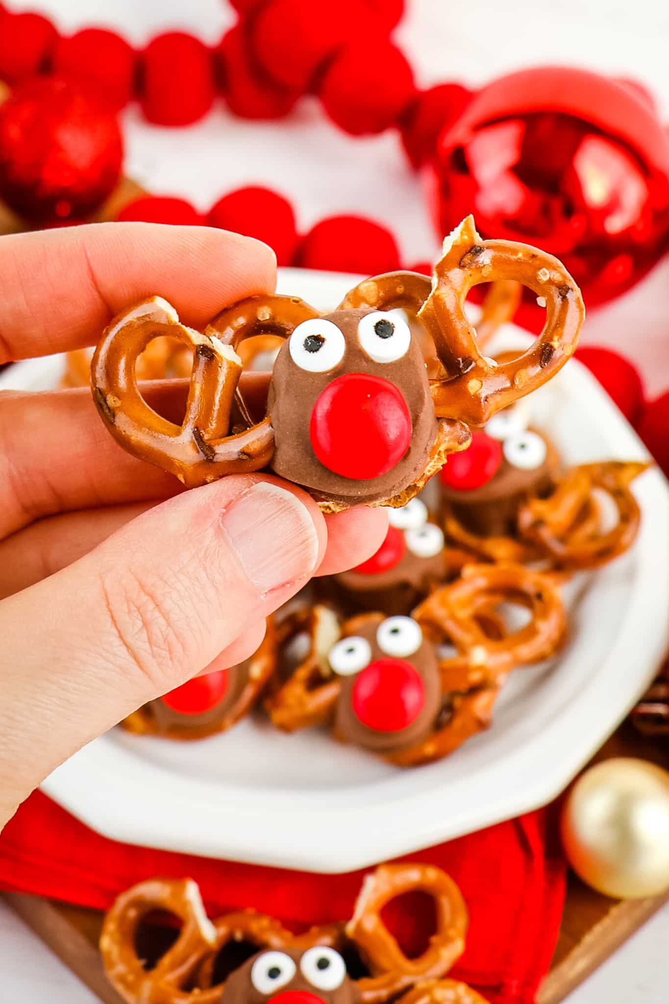 Rolo reindeer pretzel held in hand.